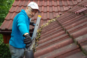 Man,On,Ladder,Cleans,Gutter,On,The,Roof.,Maintenance,Of