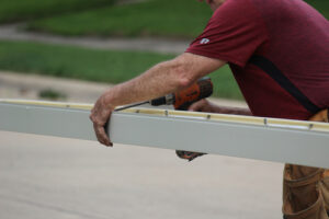 Male,Contractor,Using,A,Seamless,Gutter,Machine,To,Prepare,Seamless